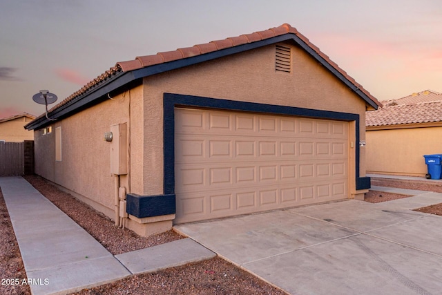 view of garage at dusk