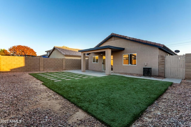 rear view of property featuring central AC, a yard, and a patio