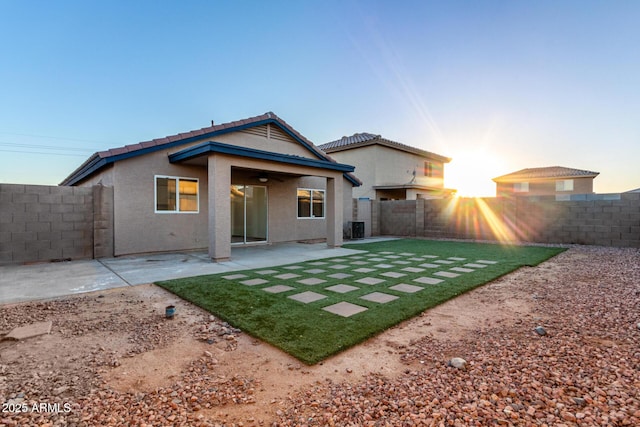 back house at dusk with a patio area