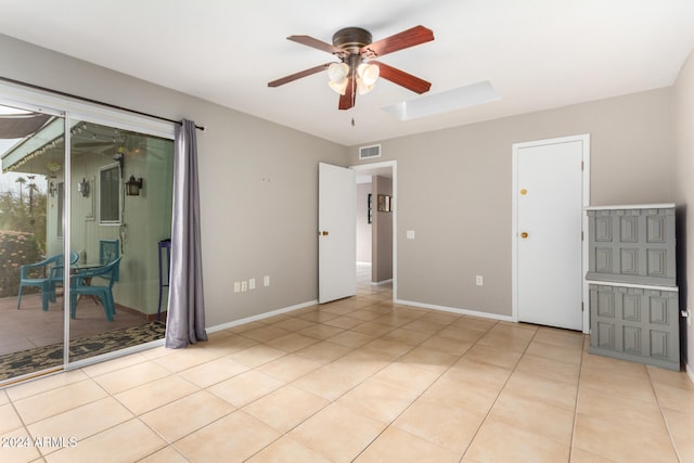 tiled empty room featuring ceiling fan