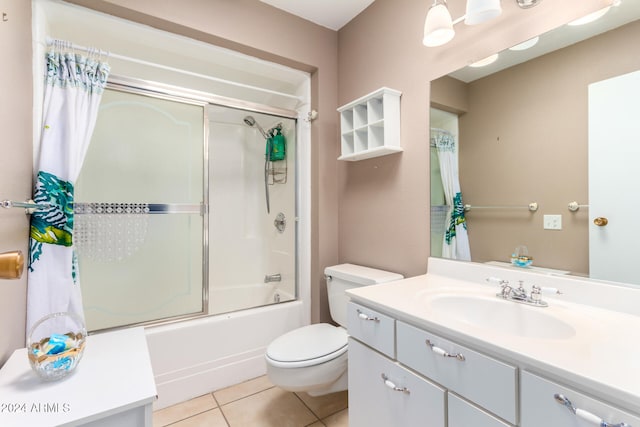 full bathroom with tile patterned floors, vanity, bath / shower combo with glass door, and toilet