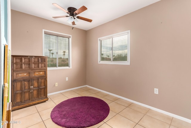 unfurnished room with ceiling fan and light tile patterned floors