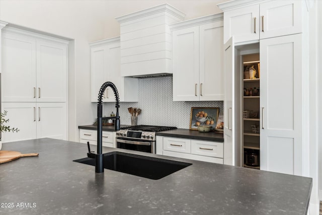 kitchen featuring white cabinetry, gas stove, custom exhaust hood, and decorative backsplash