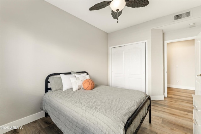 bedroom featuring hardwood / wood-style flooring, ceiling fan, and a closet