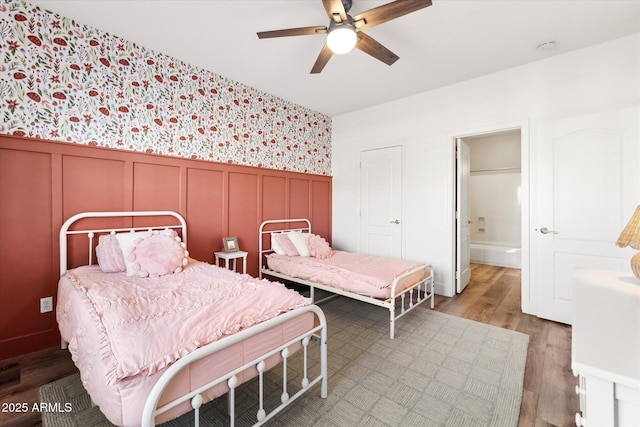 bedroom featuring hardwood / wood-style flooring, ensuite bathroom, and ceiling fan