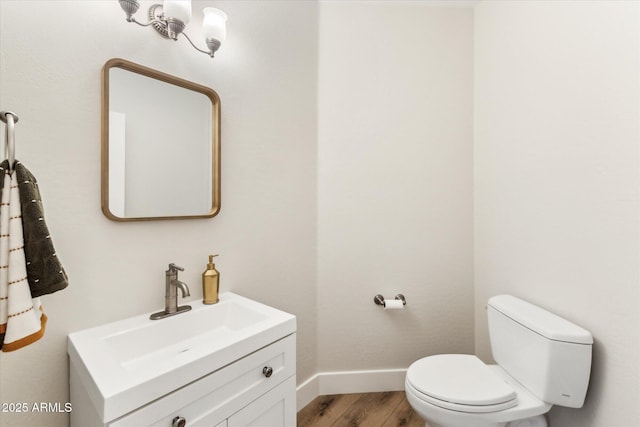 bathroom featuring wood-type flooring, vanity, and toilet