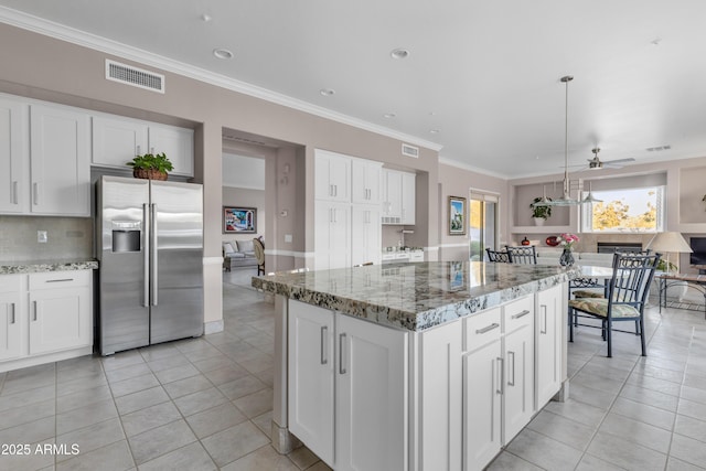 kitchen featuring ceiling fan, white cabinets, decorative light fixtures, and stainless steel fridge