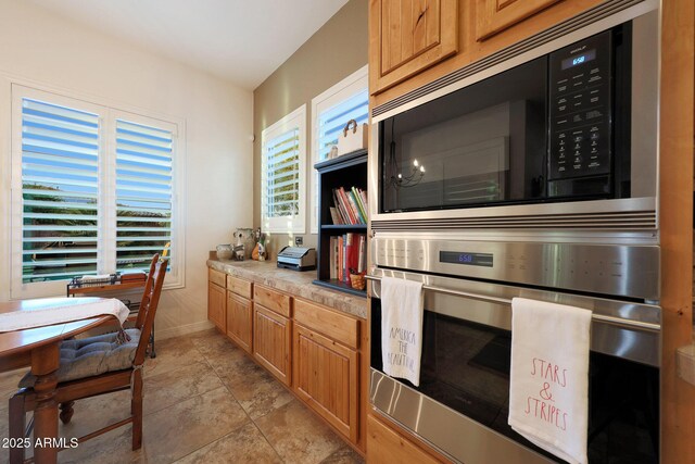19334 W Pasadena Ave, Litchfield Park, AZ 85340 - kitchen with built in microwave, oven, baseboards, light countertops, and brown cabinets
