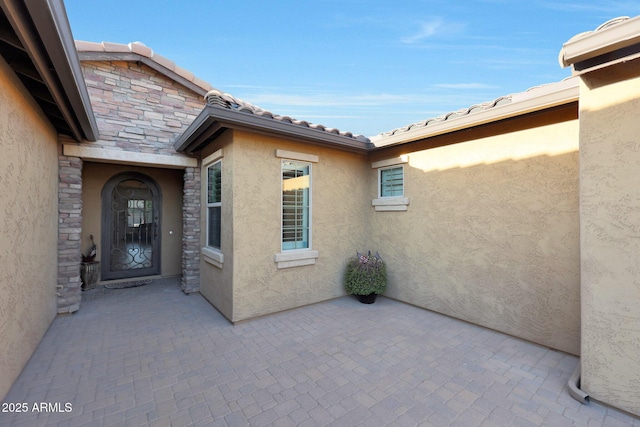 19334 W Pasadena Ave, Litchfield Park, AZ 85340 - property entrance with stone siding, stucco siding, and a patio