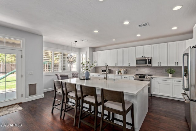 1342 E Jade Dr, Chandler, AZ 85286 - kitchen with stainless steel appliances, recessed lighting, tasteful backsplash, dark wood-type flooring, and white cabinetry