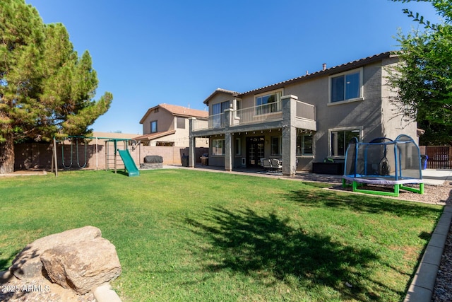 1342 E Jade Dr, Chandler, AZ 85286 - rear view of house with a trampoline, a fenced backyard, a balcony, a patio area, and a playground