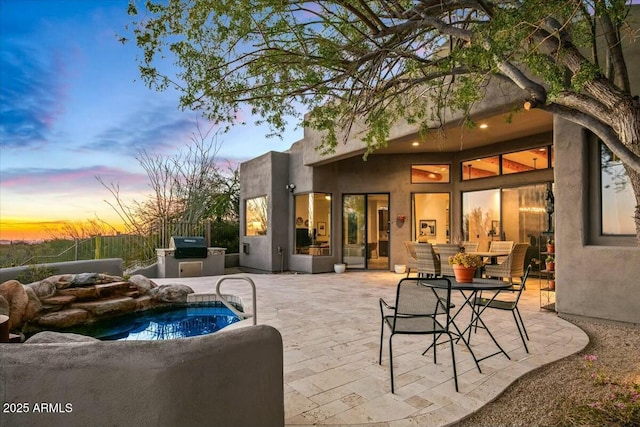 view of patio with exterior kitchen and a grill