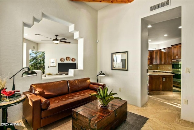 living room with ceiling fan, visible vents, and recessed lighting