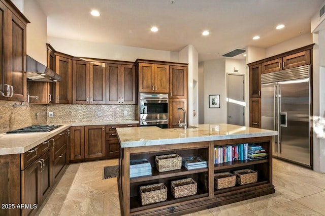 kitchen featuring stainless steel appliances, a sink, wall chimney exhaust hood, backsplash, and open shelves