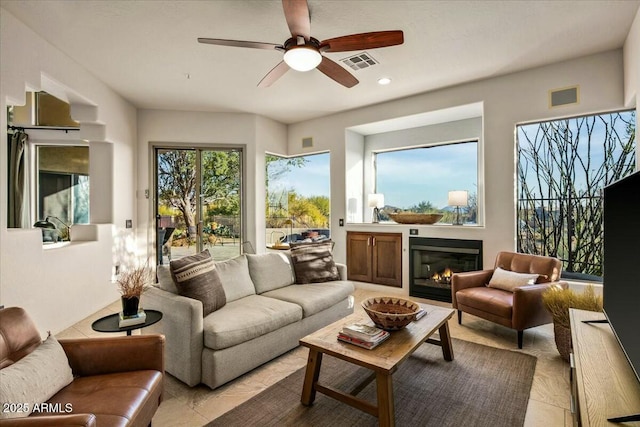 living room featuring recessed lighting, visible vents, a ceiling fan, and a glass covered fireplace