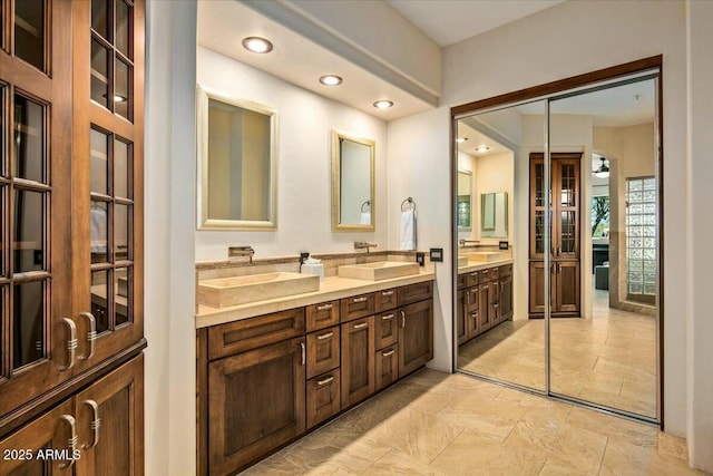 full bath with double vanity, a sink, and recessed lighting