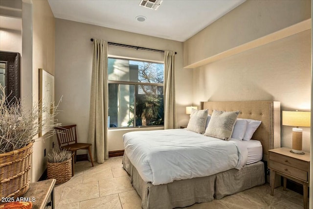 bedroom featuring stone tile floors and visible vents