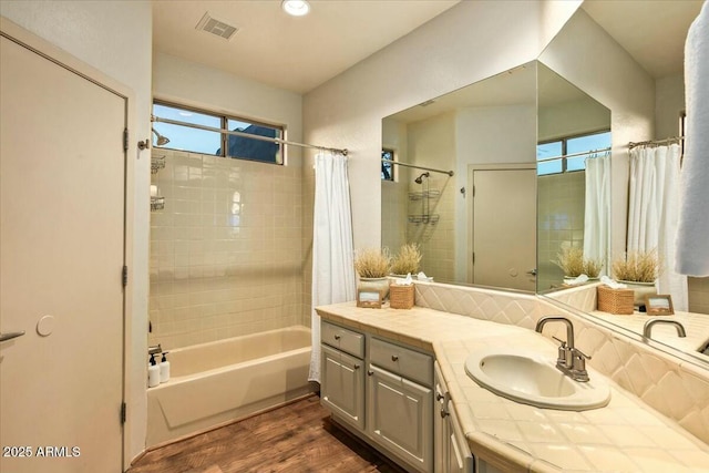 bathroom featuring vanity, visible vents, wood finished floors, and shower / tub combo with curtain