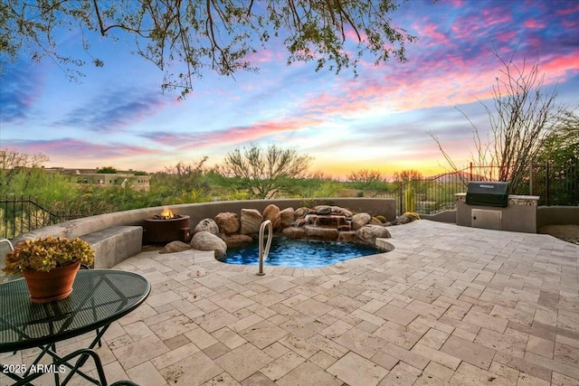 view of pool with a fire pit, a patio, an outdoor kitchen, and fence