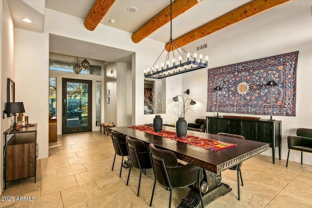 dining space with beam ceiling and visible vents