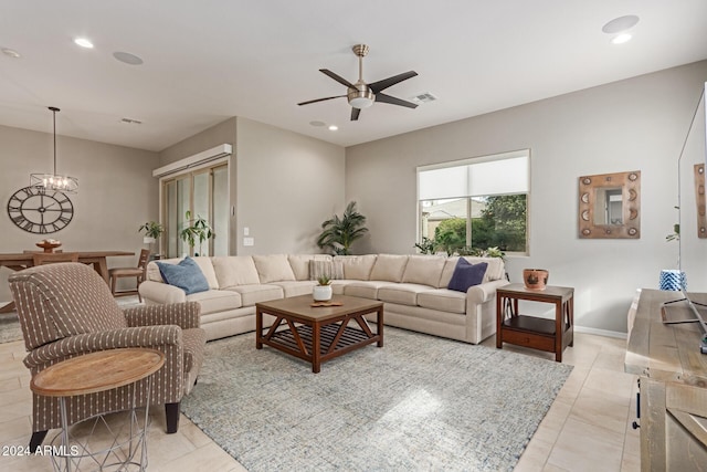 living room with ceiling fan with notable chandelier and light tile patterned floors