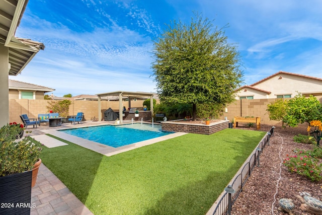 view of pool featuring outdoor lounge area, pool water feature, a patio area, and a lawn