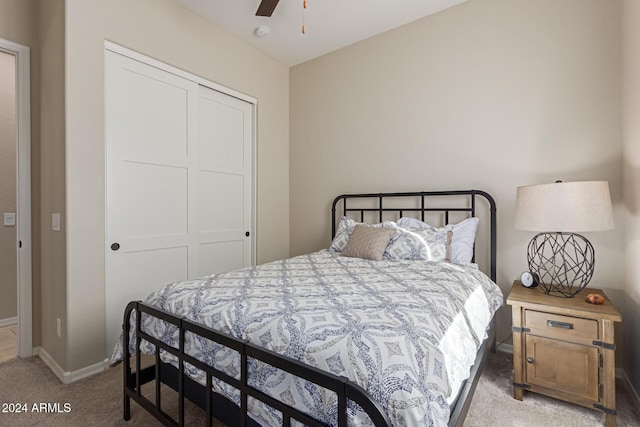 bedroom featuring ceiling fan, a closet, and light colored carpet