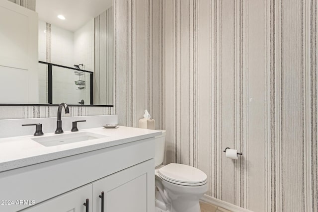 bathroom featuring tile patterned floors, vanity, toilet, and walk in shower