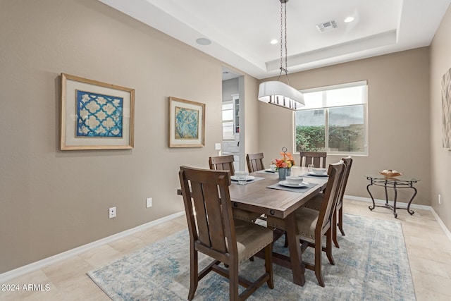 tiled dining room with a tray ceiling