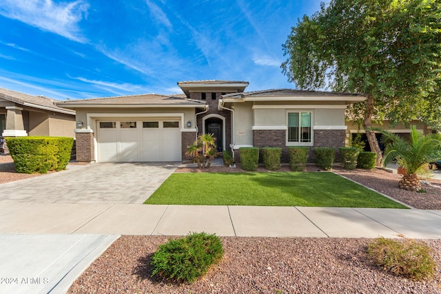 prairie-style home featuring a garage and a front lawn