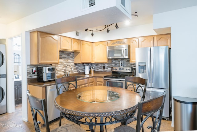 kitchen with sink, backsplash, appliances with stainless steel finishes, and light brown cabinets