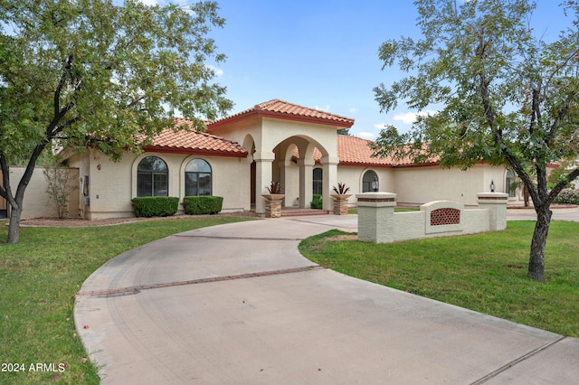 mediterranean / spanish home featuring a front lawn