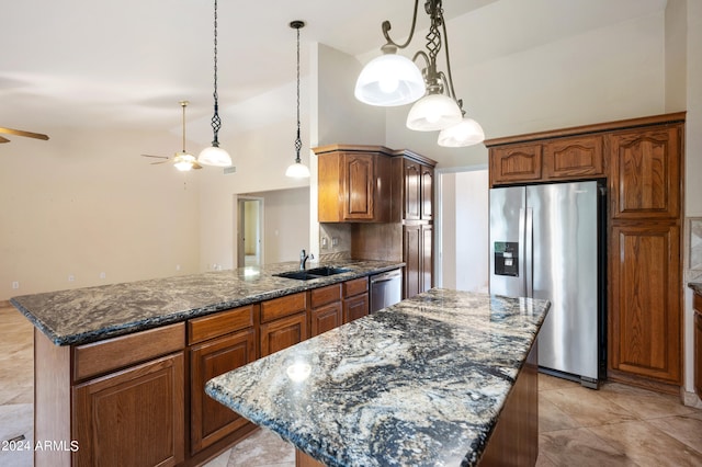 kitchen with a kitchen island, hanging light fixtures, dark stone counters, sink, and appliances with stainless steel finishes