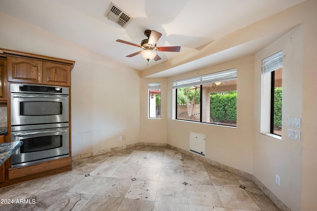 kitchen featuring double oven, vaulted ceiling, and ceiling fan