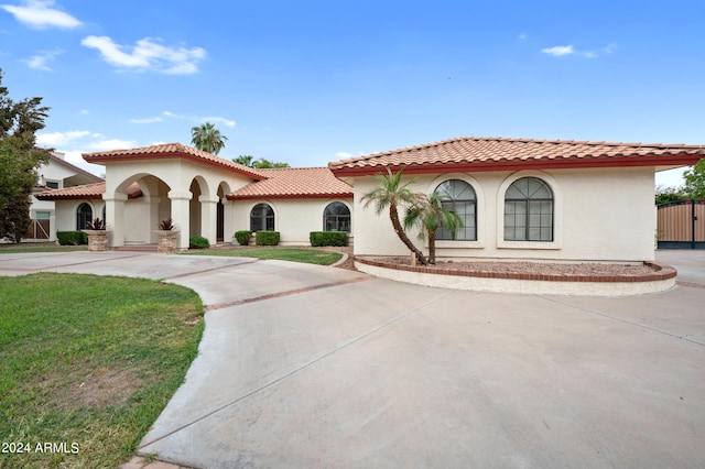 mediterranean / spanish-style home with a front lawn