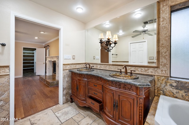 bathroom featuring tile walls, vanity, crown molding, hardwood / wood-style flooring, and a bathtub