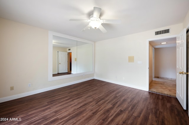 spare room with dark wood-type flooring and ceiling fan