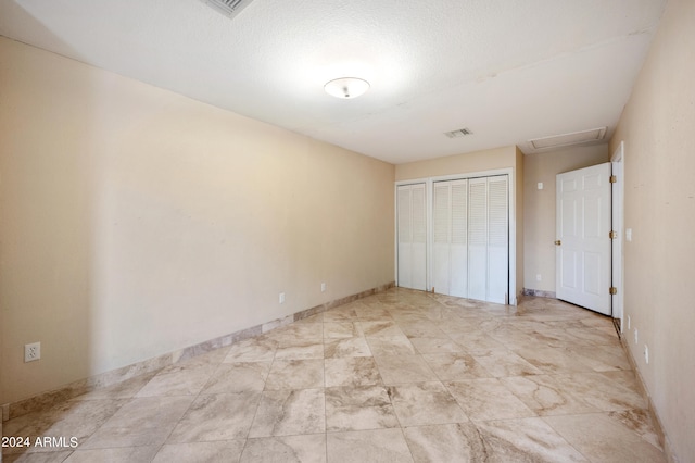 unfurnished bedroom with a textured ceiling