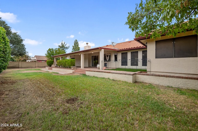 back of property with a patio and a lawn