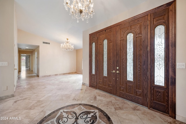 foyer featuring vaulted ceiling and a chandelier