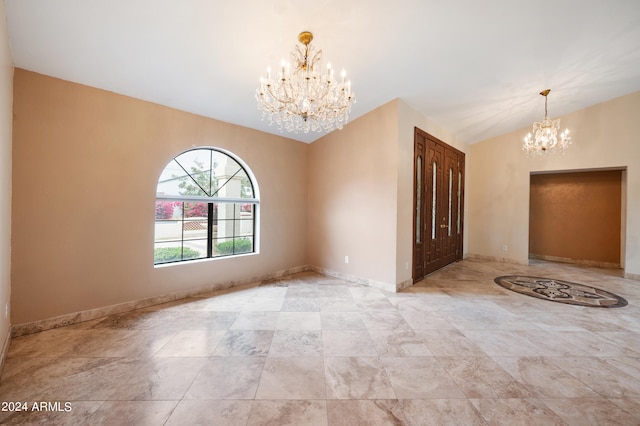 spare room with an inviting chandelier and vaulted ceiling