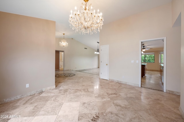 empty room with high vaulted ceiling and ceiling fan with notable chandelier