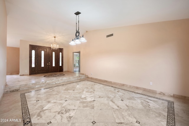 foyer entrance featuring vaulted ceiling and an inviting chandelier