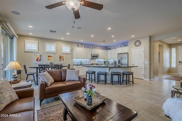 living room with light tile patterned floors and ceiling fan