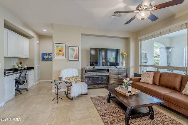 living room featuring light tile patterned flooring, built in desk, and ceiling fan