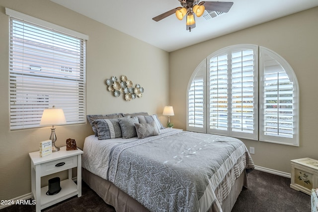 carpeted bedroom with multiple windows and ceiling fan