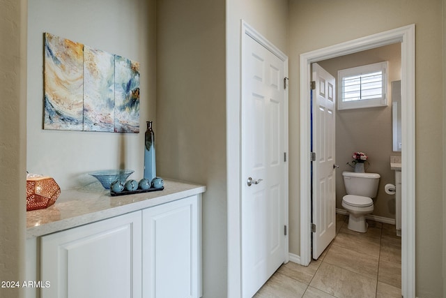 bathroom with toilet and tile patterned flooring