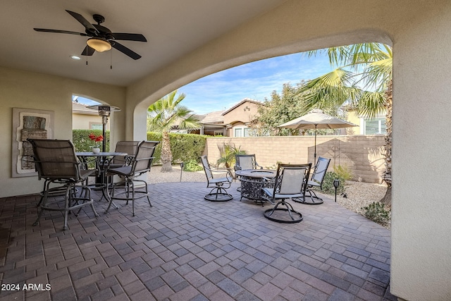 view of patio / terrace with ceiling fan and a fire pit