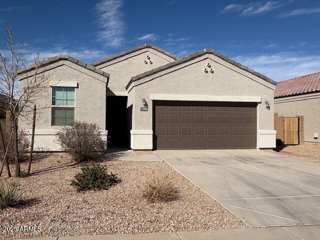 view of front of property featuring an attached garage, concrete driveway, and stucco siding