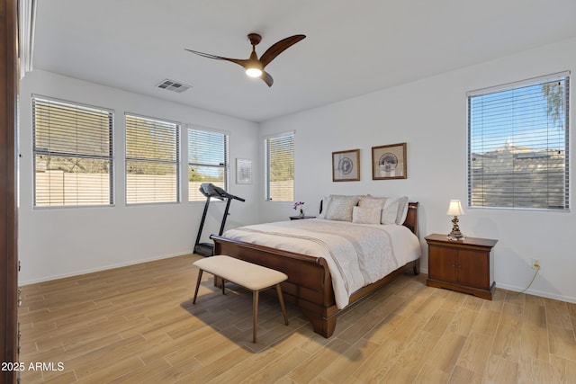 bedroom featuring baseboards, light wood-style floors, visible vents, and a ceiling fan